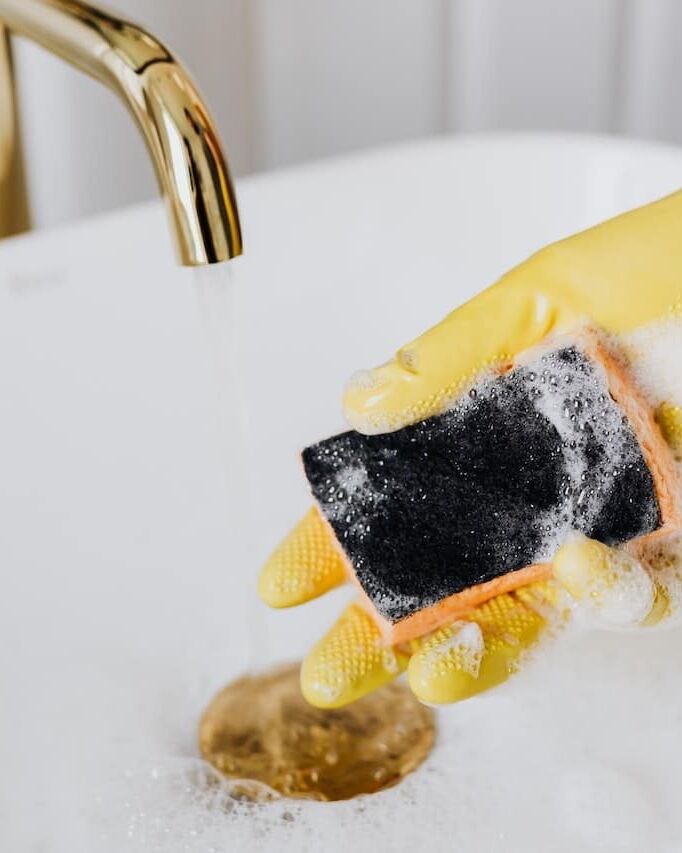 gule handsker og en skuresvamp